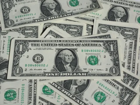 Dólar abaixo de R$ 5: o que explica a queda da moeda e como investir neste cenário